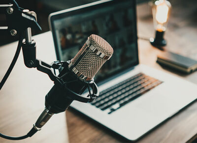 a podcast recording microphone and laptop on top of desk