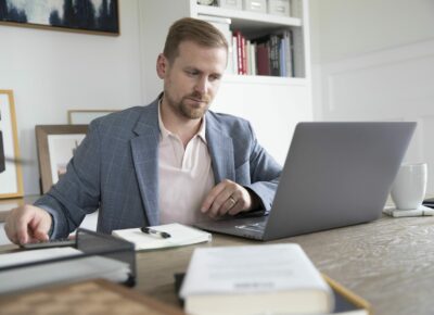 A man works on a laptop at a desk.