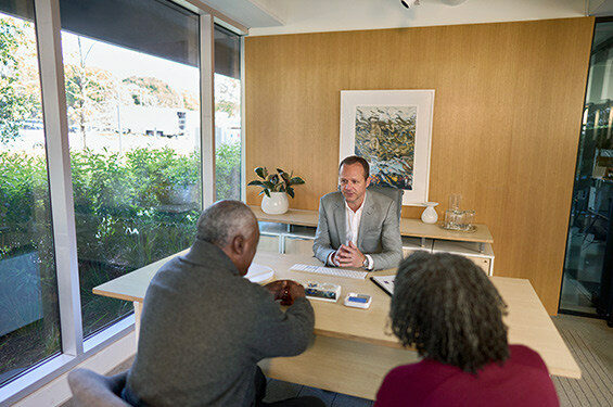 A business man speaks to clients in his office.