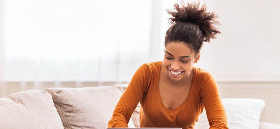 Happy African American Lady Freelancer Using Laptop Working Online From Home Sitting On Sofa Indoor. Copy Space, Selective Focus