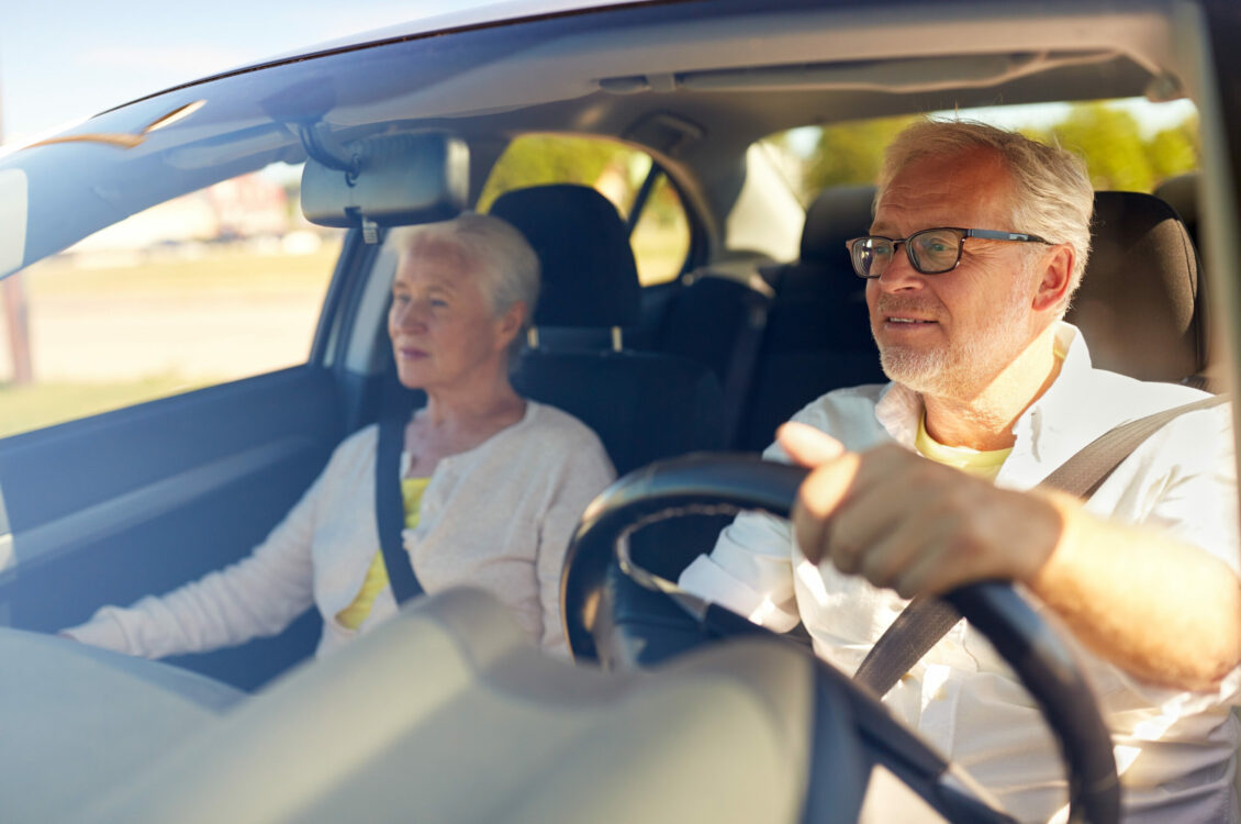 happy senior couple driving in car