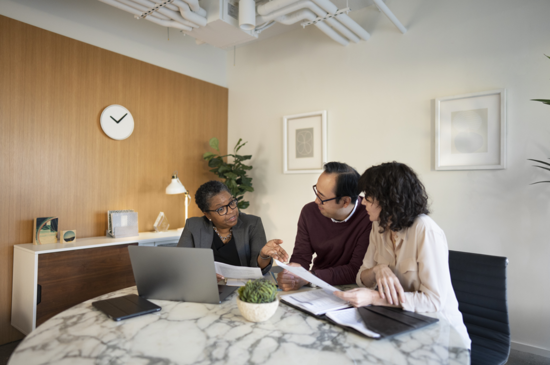 A professional talking to a couple about some papers.