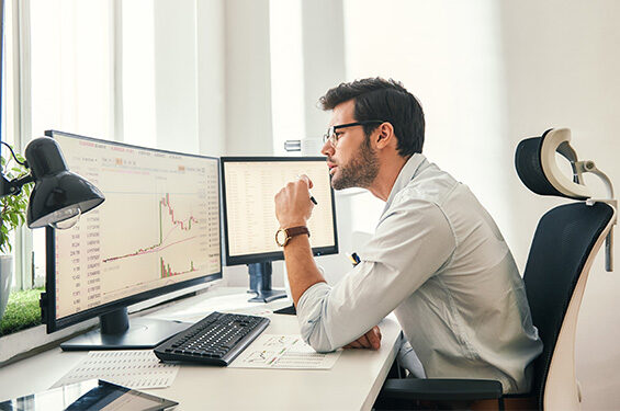 Man looks at charts on a computer.