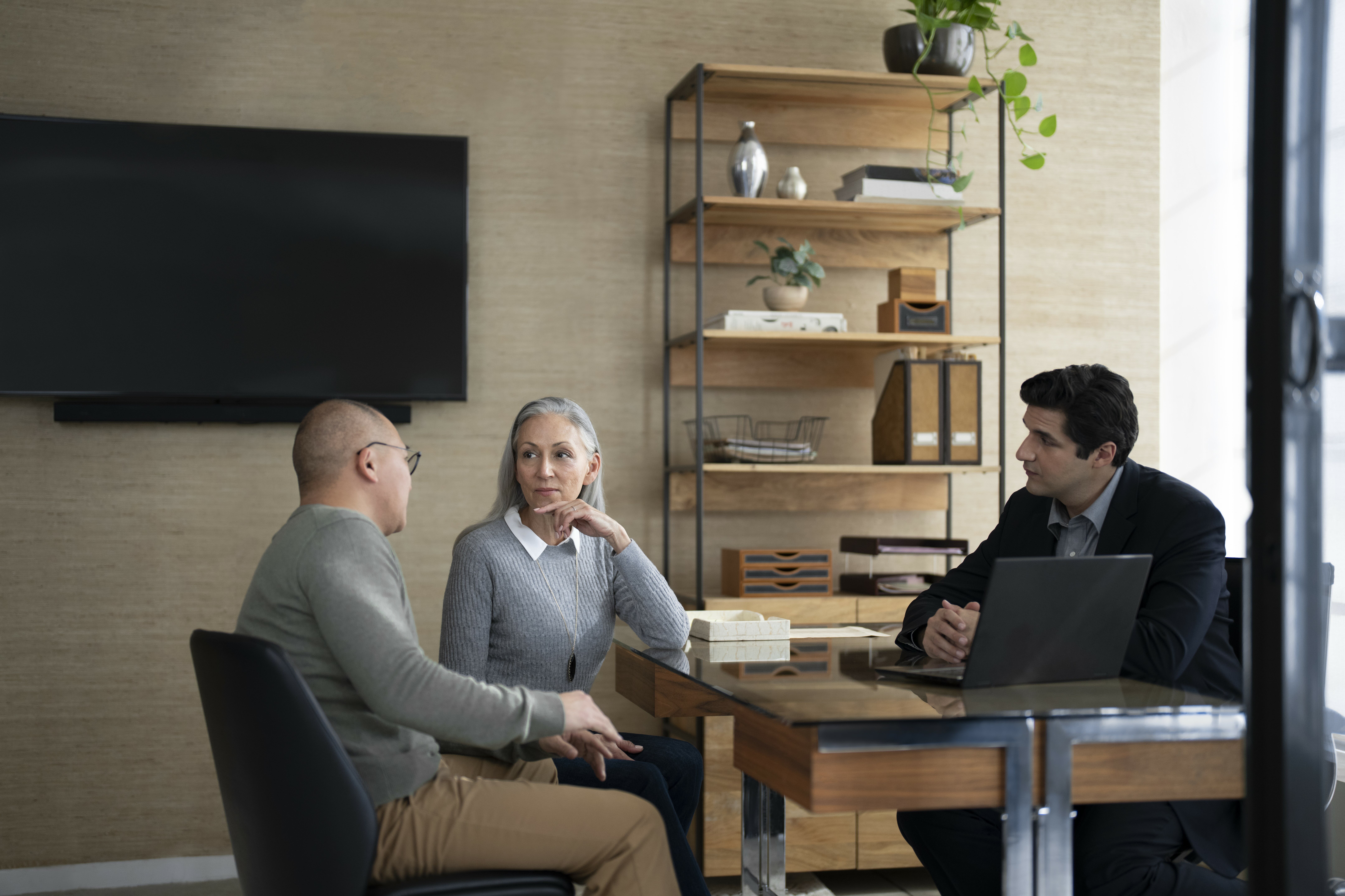 A group of three people having a discussion in the office.