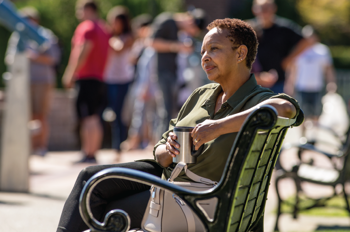 A woman sitting on a bench outside.