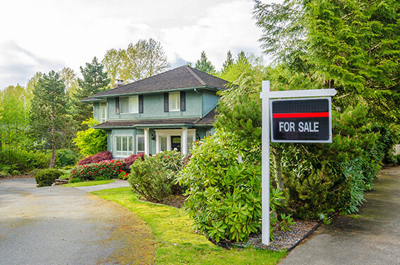 For sale sign placed near a house.