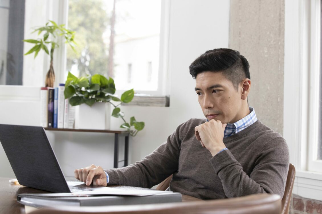 A man scrolls on a computer.